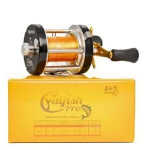 A fishing reel resting on a yellow box.