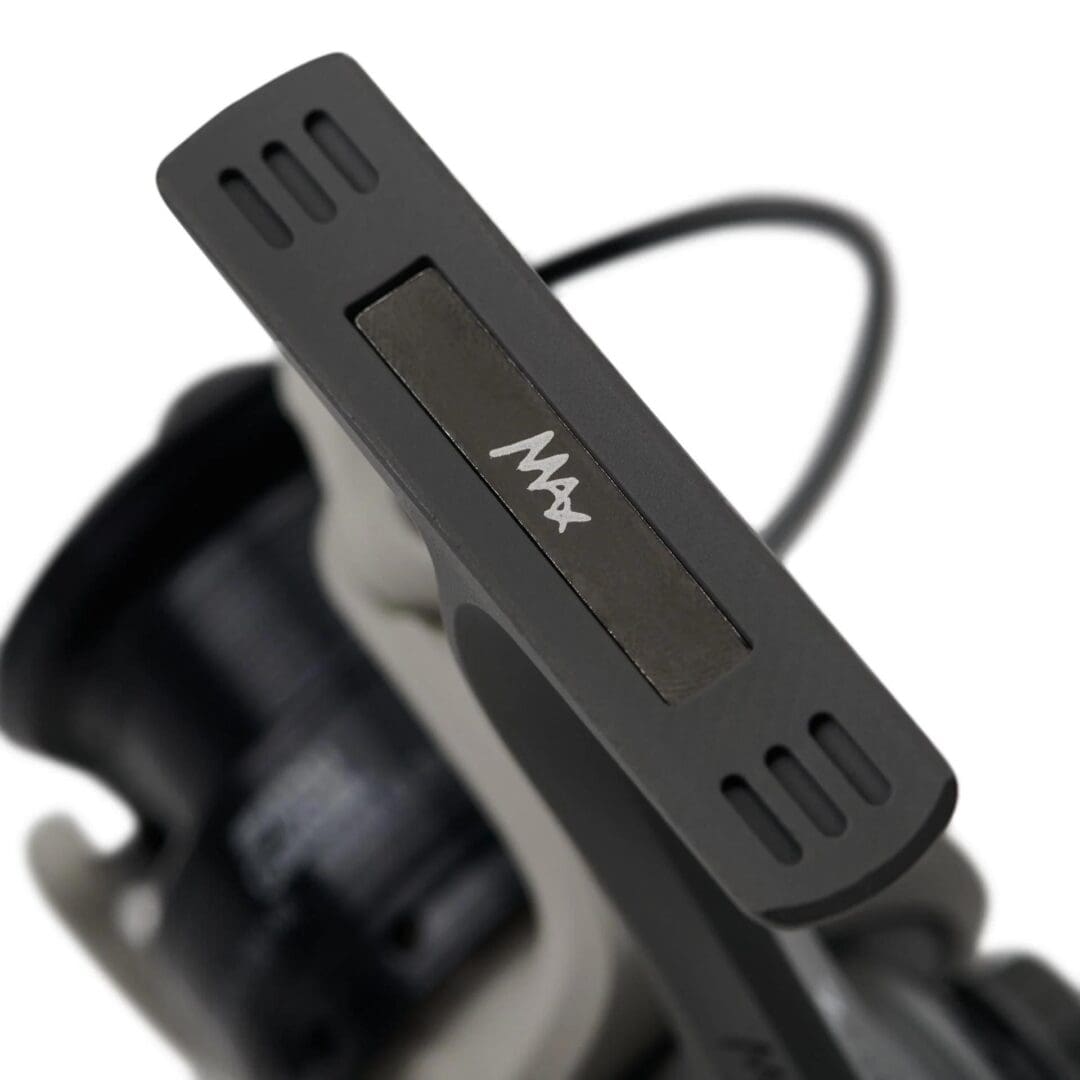 Close-up of a black fishing reel's drag adjustment knob.